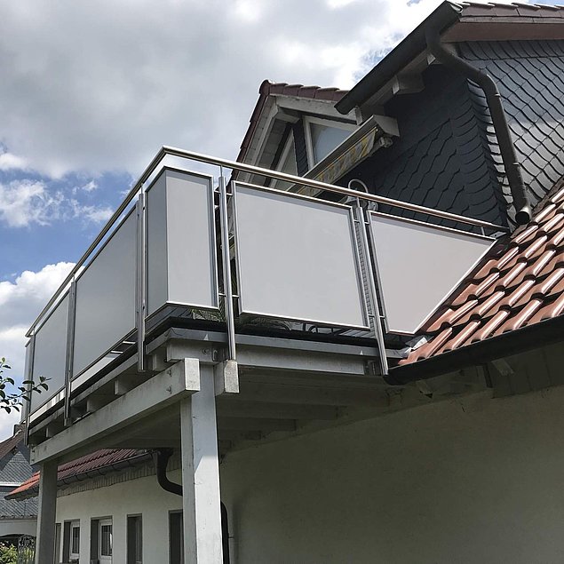 Edelstahl-Balkongeländer mit Füllelementen aus pulverbeschichtetem Aluminiumblech Bild eines Edelstahl-Balkongeländers mit Füllelementen aus pulverbeschichtetem Aluminiumblech