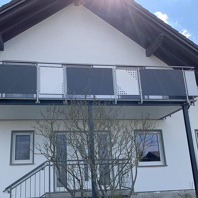 Edelstahlgeländer mit Handlauf und Pfosten aus Rundrohr und Füllungen bestehend aus Trespa-Platten und Edelstahlblech Bild eines Edelstahlgeländers mit Handlauf und Pfosten aus Rundrohr und Füllungen bestehend aus Trespa-Platten und Edelstahlblech