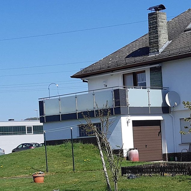 Edelstahl-Balkongeländer mit Milchglas-Füllung und unterer Abschlussblende Bild eines Edelstahl-Balkongeländers mit Milchglas-Füllung und unterer Abschlussblende