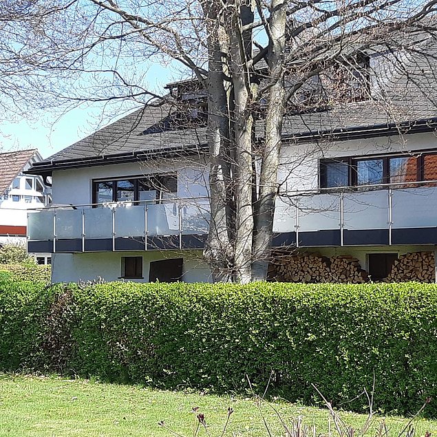 Edelstahl-Balkongeländer mit Milchglas-Füllung und unterer Abschlussblende Bild eines Edelstahl-Balkongeländers mit Milchglas-Füllung und unterer Abschlussblende